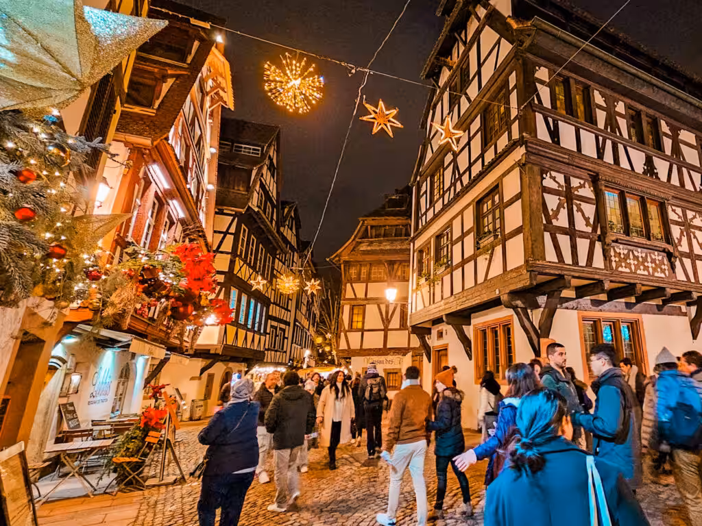A half-timbered street in Strasbourg lit up for Christmas